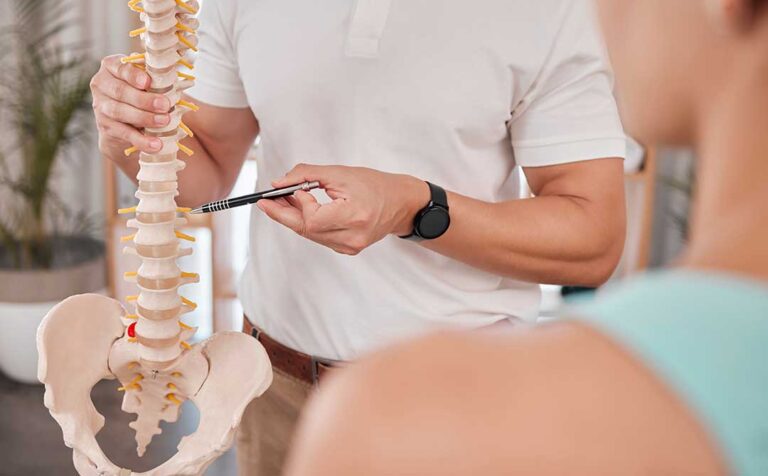 An adult receives a gentle spinal adjustment from a chiropractor in a bright, calming office setting.